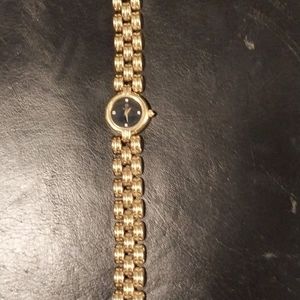 Ladies gold tone watch with black face